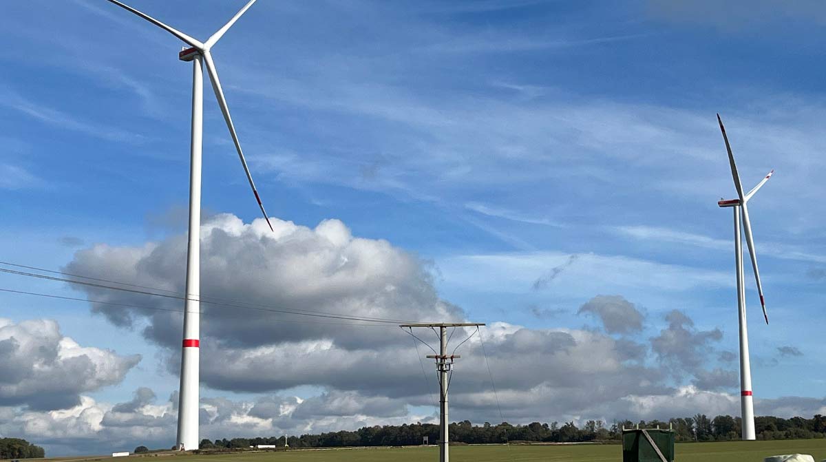 Zwei Windkraftanlagen hinter einem Feld