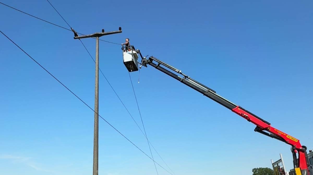 Reparatur direkt am Strommast in der Höhe mithilfe eine Kranwagens